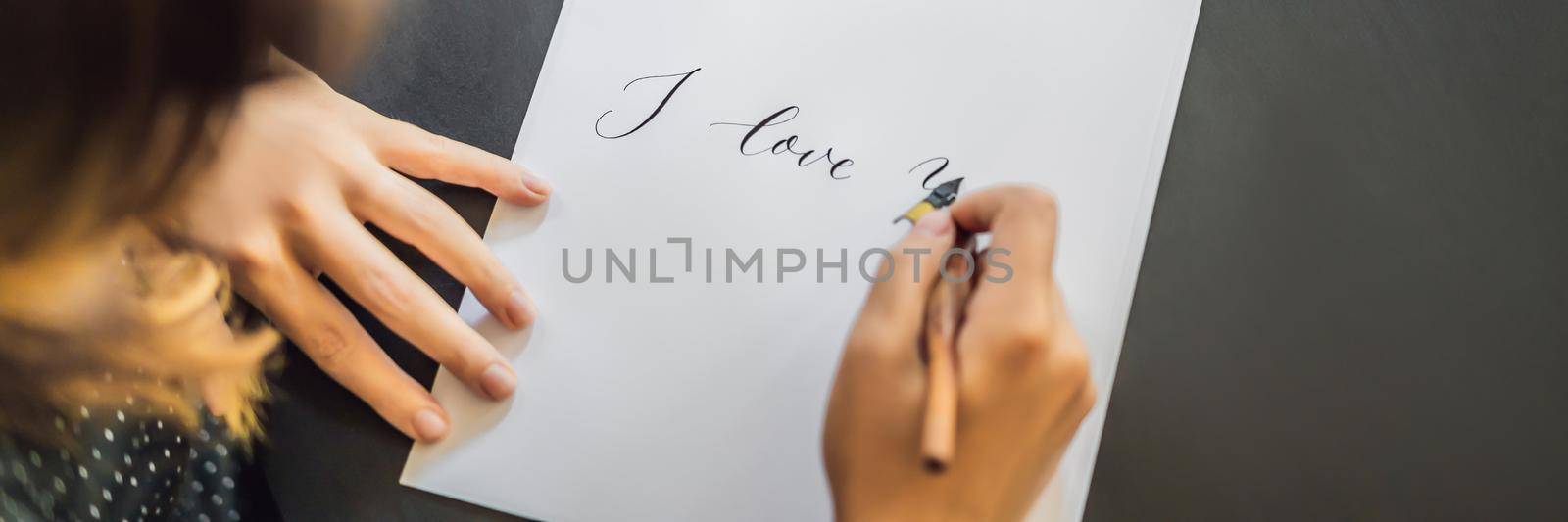I love you. Calligrapher Young Woman writes phrase on white paper. Inscribing ornamental decorated letters. Calligraphy, graphic design, lettering, handwriting, creation concept. BANNER, LONG FORMAT
