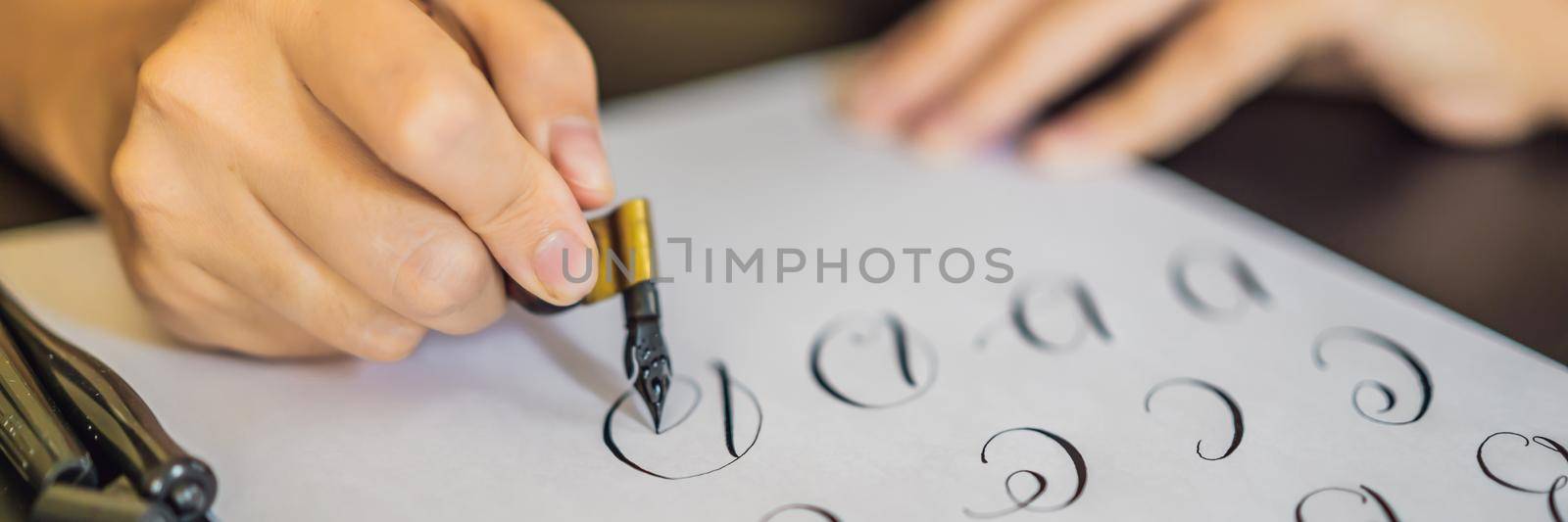 BANNER, LONG FORMAT Calligrapher Young Woman writes phrase on white paper. Inscribing ornamental decorated letters. Calligraphy, graphic design, lettering, handwriting, creation concept.