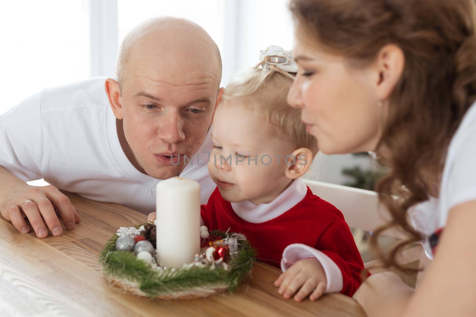 Baby child with hearing aid and cochlear implant having fun with parents in christmas room. Deaf , diversity and health concept by Satura86