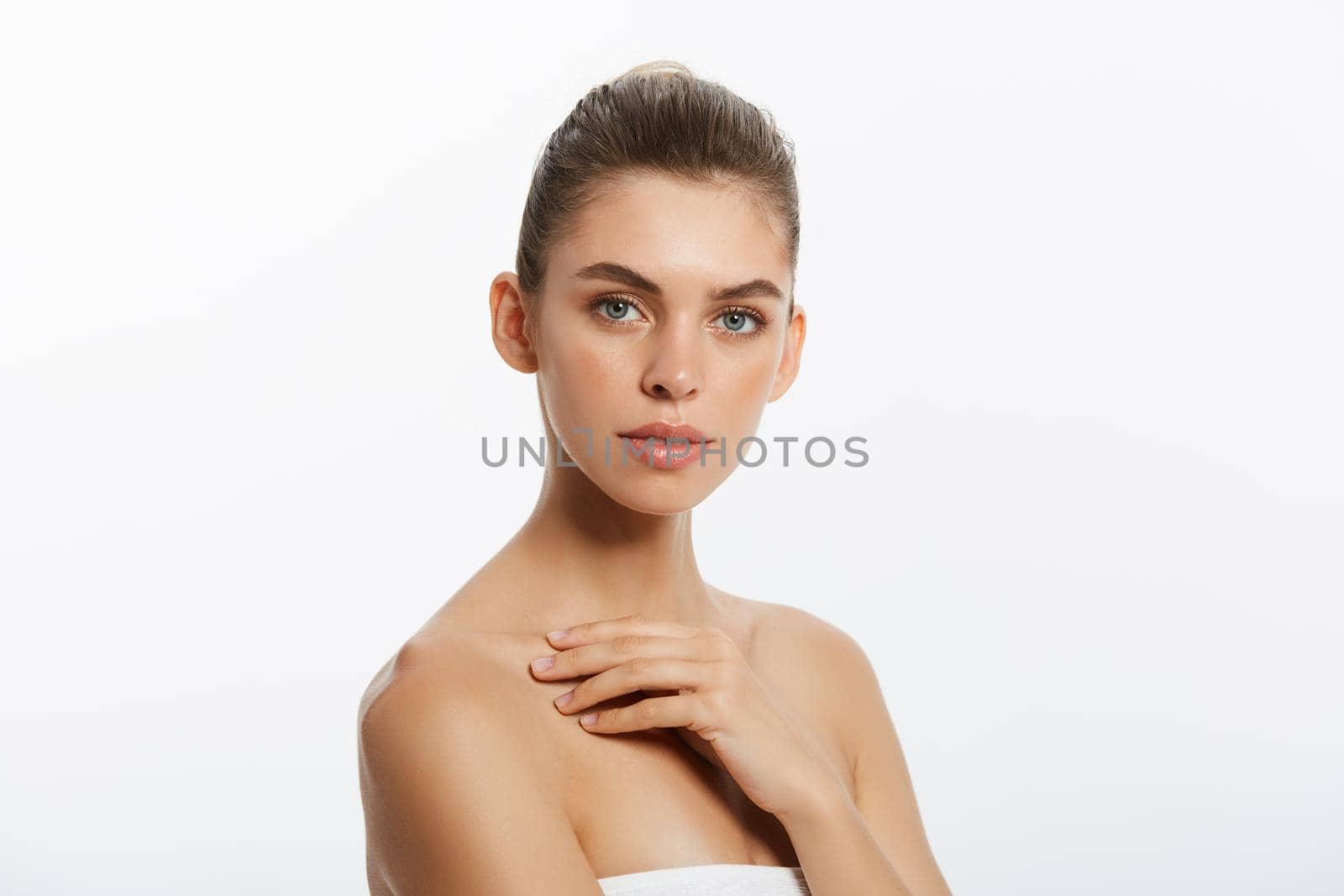 Beautiful Caucasian woman with towel against a white background