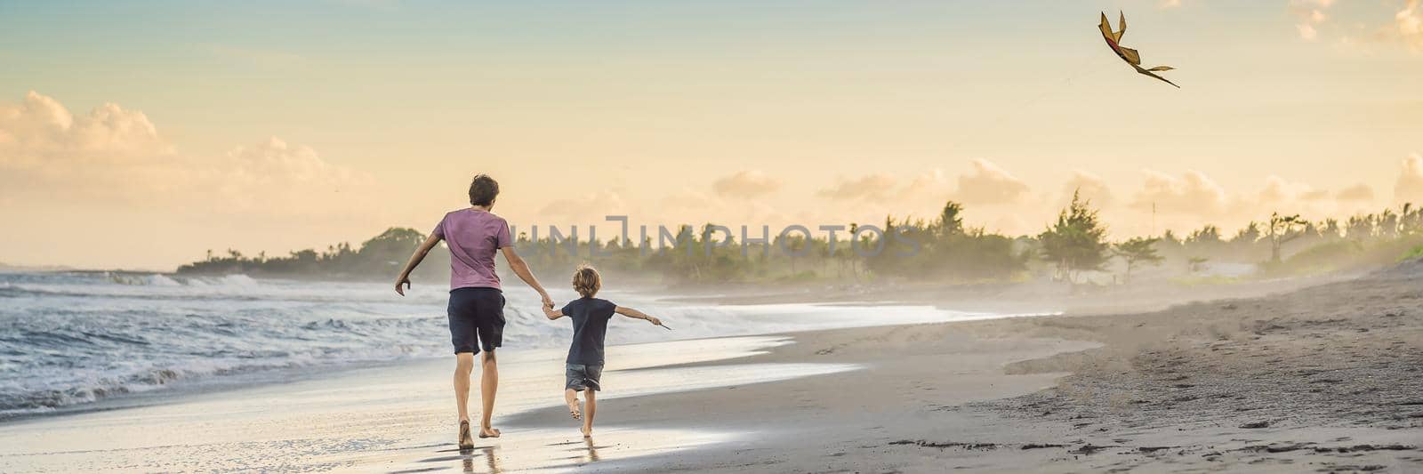 Young father and his son running with kite on the beach BANNER, LONG FORMAT by galitskaya