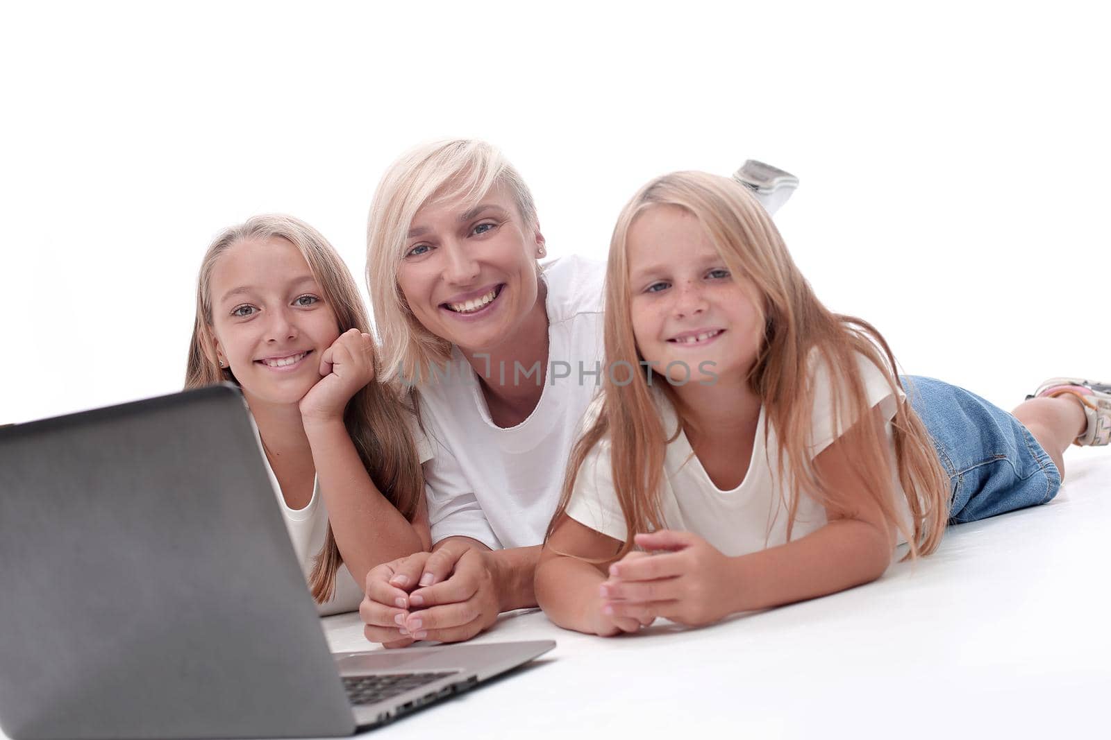 close up. mom and daughters lying in front of an open laptop. people and technology