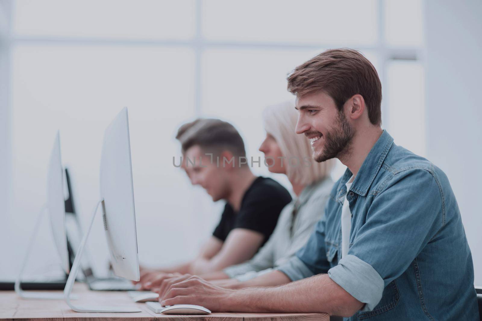 close up. successful young man sitting at the office Desk by asdf