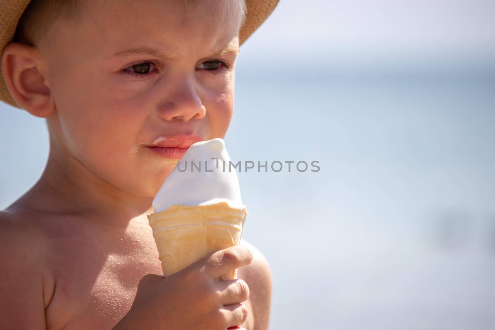 the child cries and eats ice cream on the beach. selective focus
