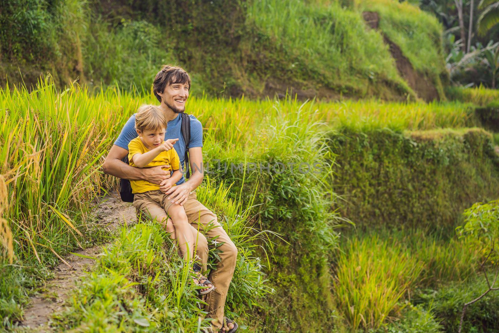 Dad and son travelers on Beautiful Rice Terraces against the background of famous volcanoes in Bali, Indonesia Traveling with children concept.