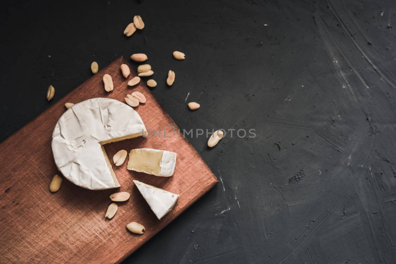 cheese camembert with mold and nuts on the wooden cutting board