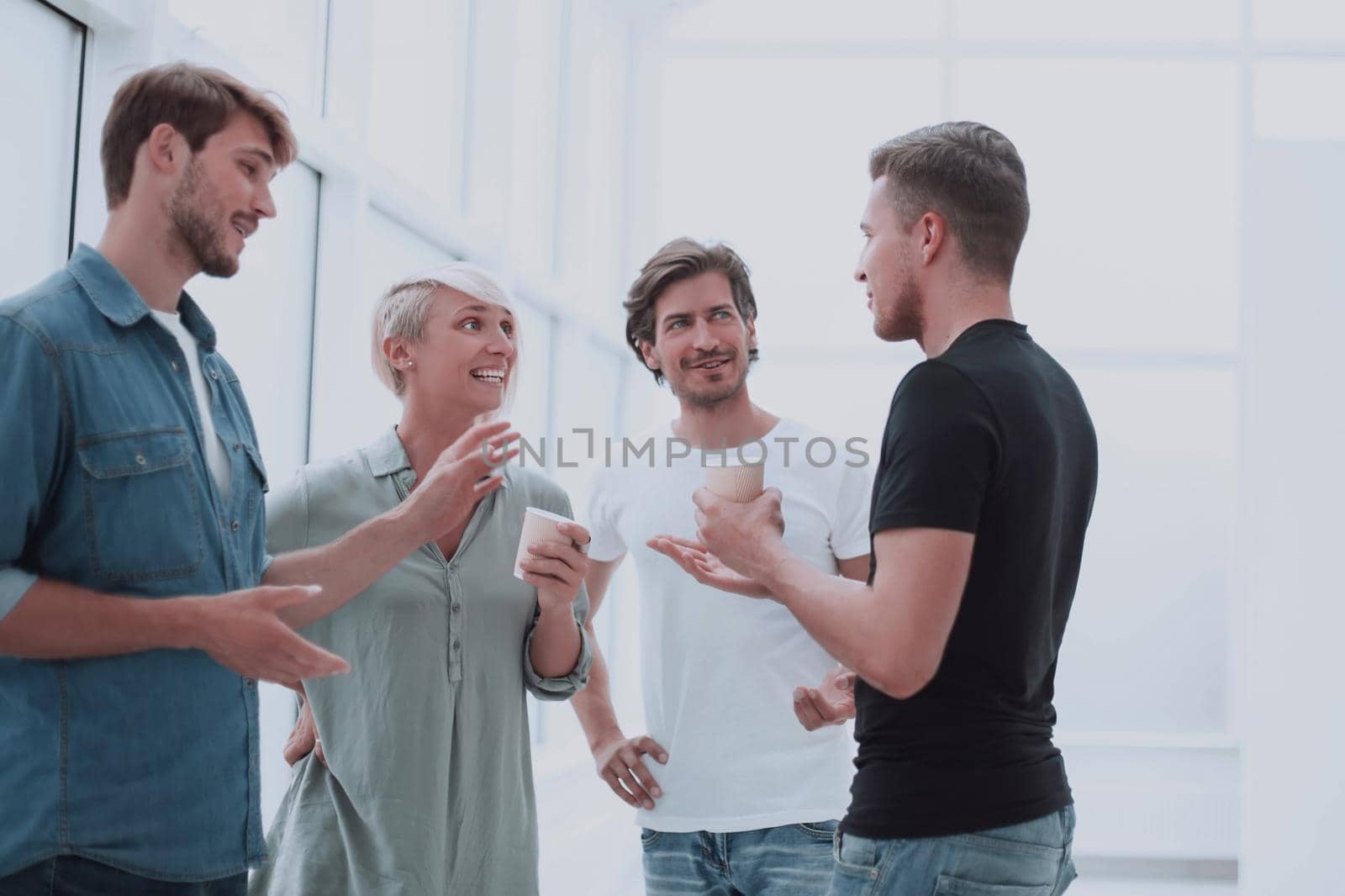 group of co-workers are discussing something in the office corridor by asdf
