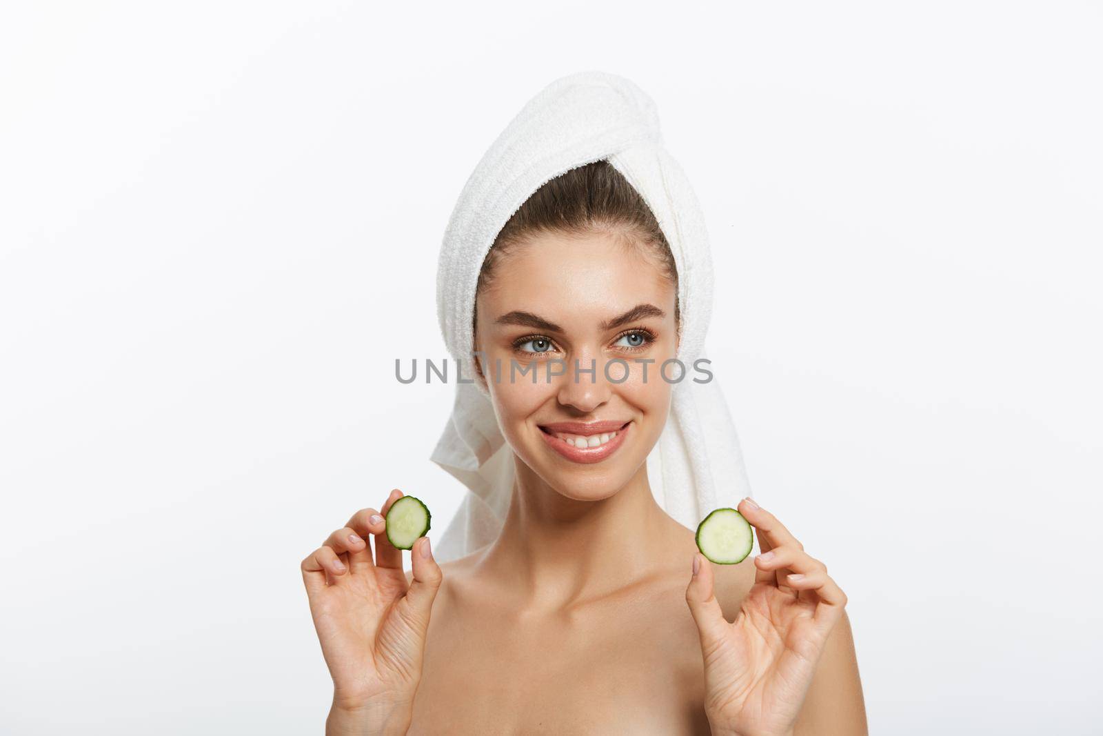 Woman with facial mask and cucumber slices in her hands on white background by Benzoix