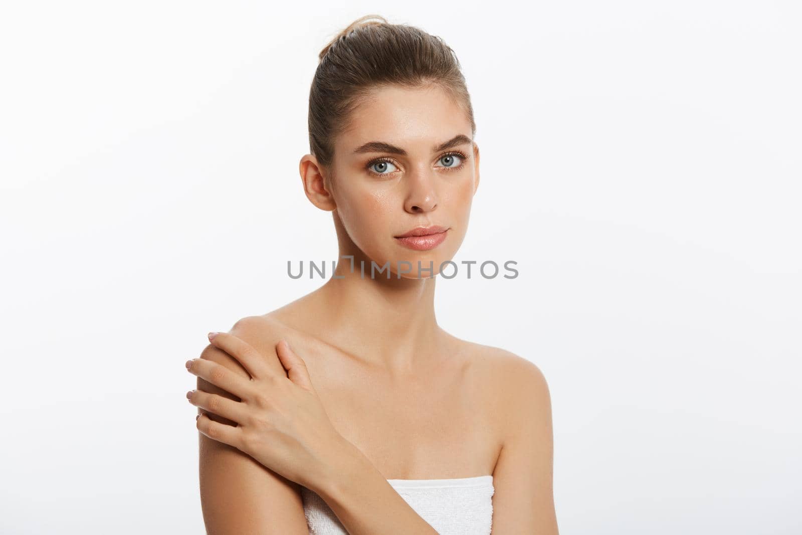 Beautiful Caucasian woman with towel against a white background
