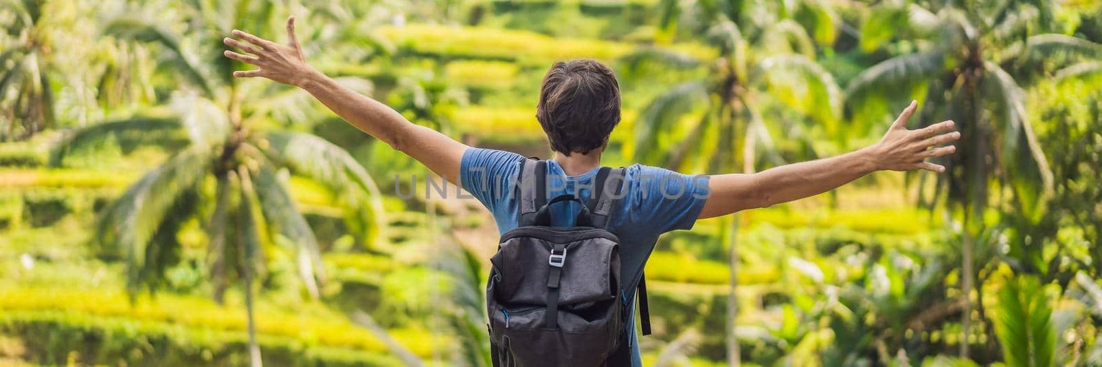 Male tourist with a backpack goes on the rice field BANNER, LONG FORMAT by galitskaya
