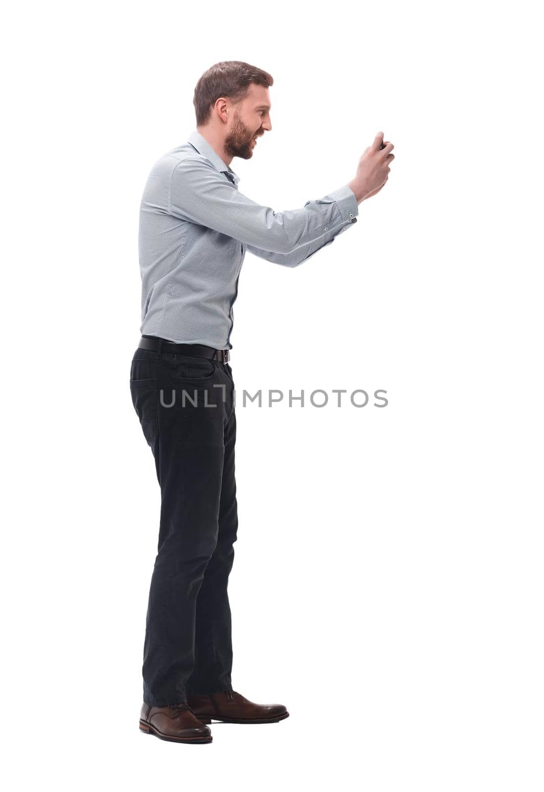 side view. attractive young businessman taking selfie on his smartphone. isolated on white