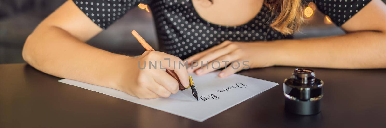 BANNER, LONG FORMAT dream big set goals take action. Calligrapher Young Woman writes phrase on white paper. Inscribing ornamental decorated letters. Calligraphy, graphic design, lettering, handwriting, creation concept by galitskaya