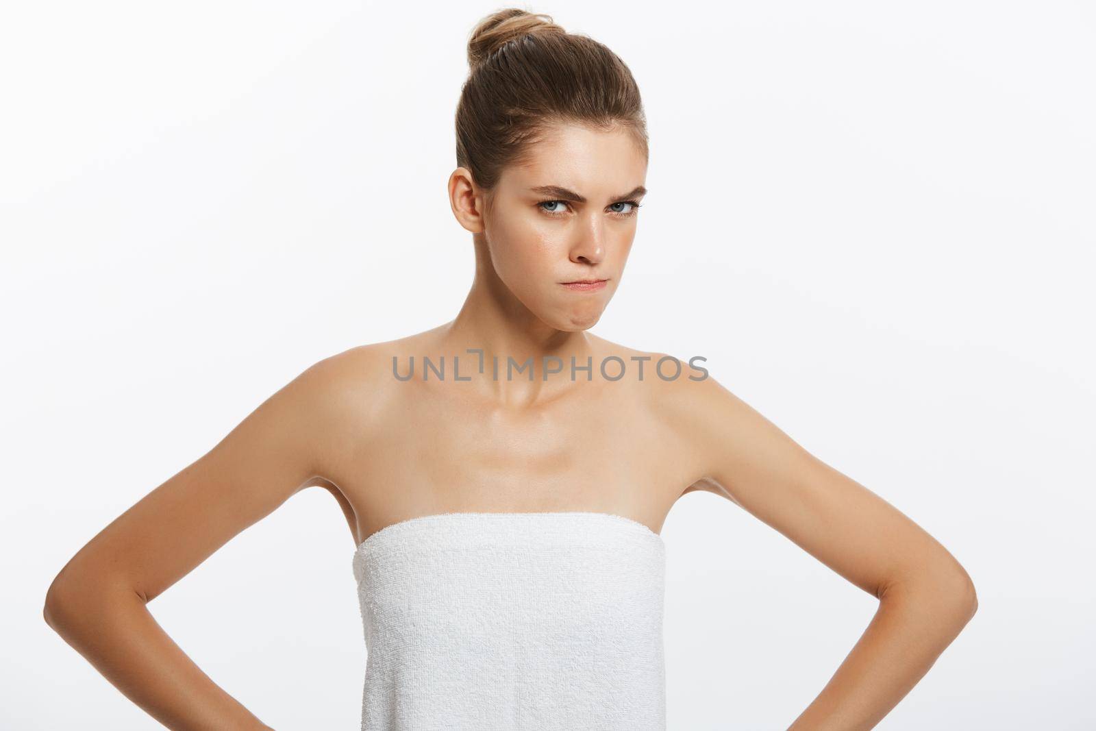 Frustrated upset mad angry woman with towel covering breast. Isolated on white.