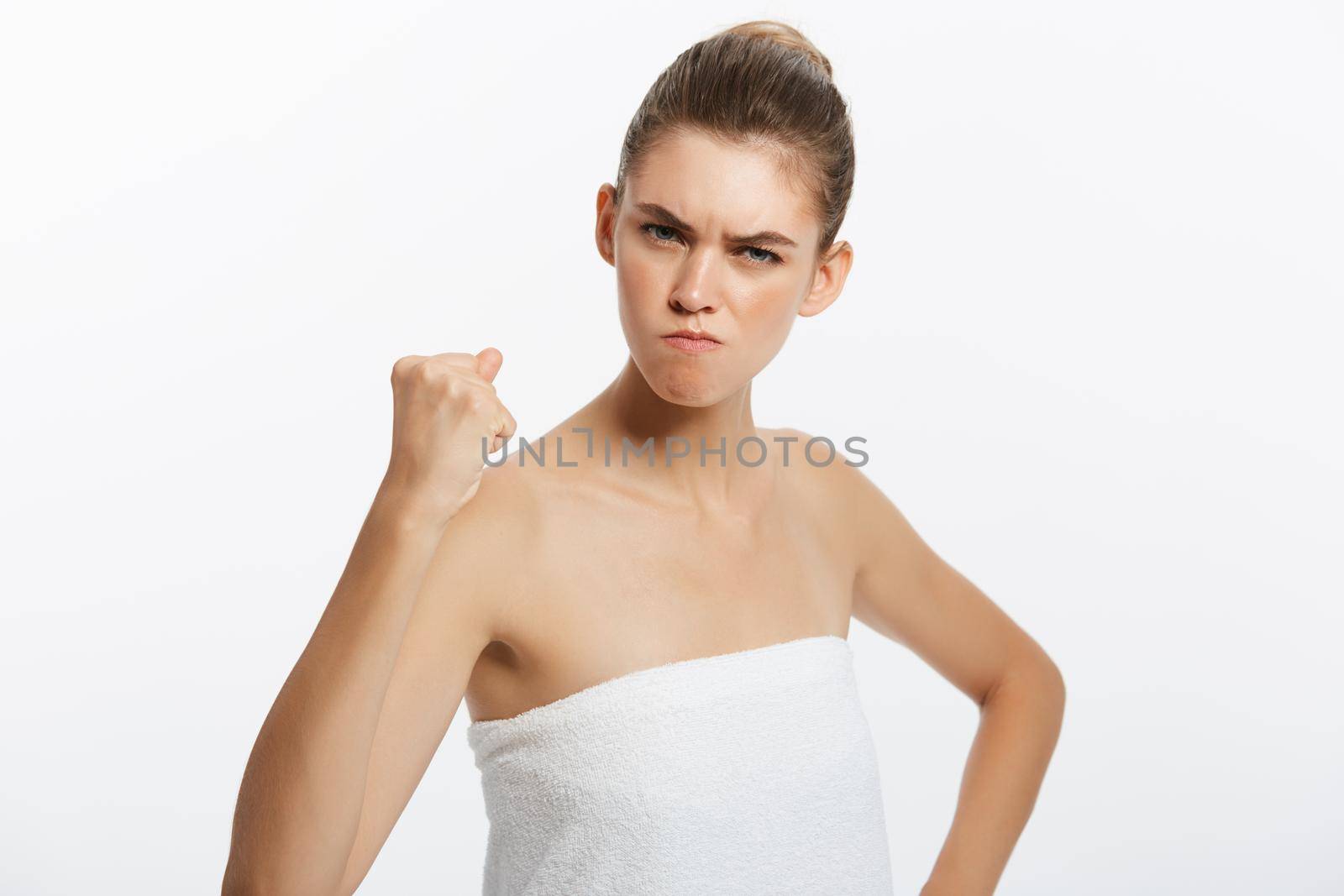 Frustrated upset mad angry woman with towel covering breast. Isolated on white.