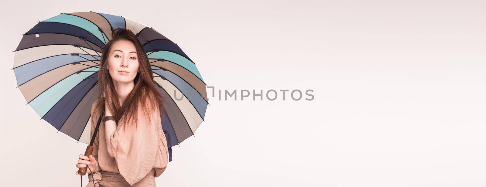 Pretty asian woman korean or japanese stands under umbrella white background with copy space banner