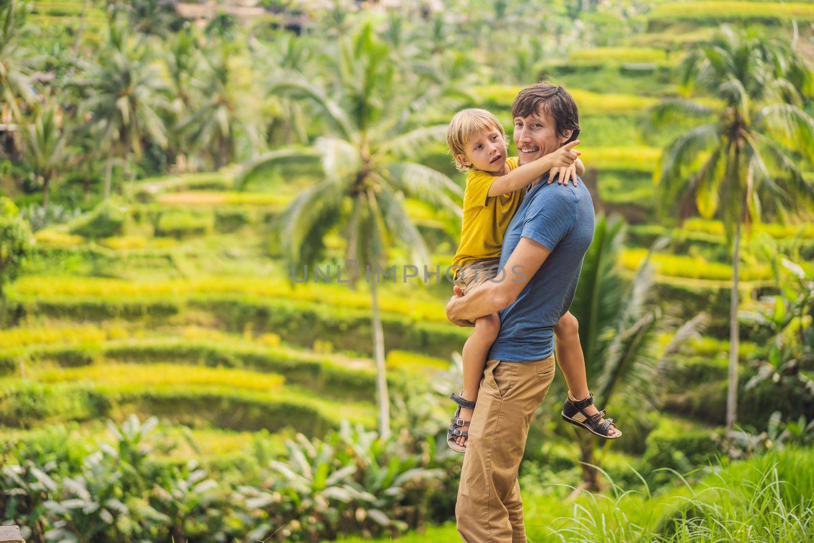 Dad and son travelers on Beautiful Rice Terraces against the background of famous volcanoes in Bali, Indonesia Traveling with children concept.