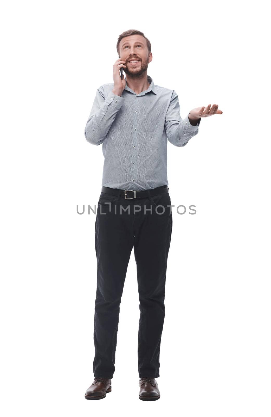 in full growth. young businessman talking on his smartphone. isolated on white background