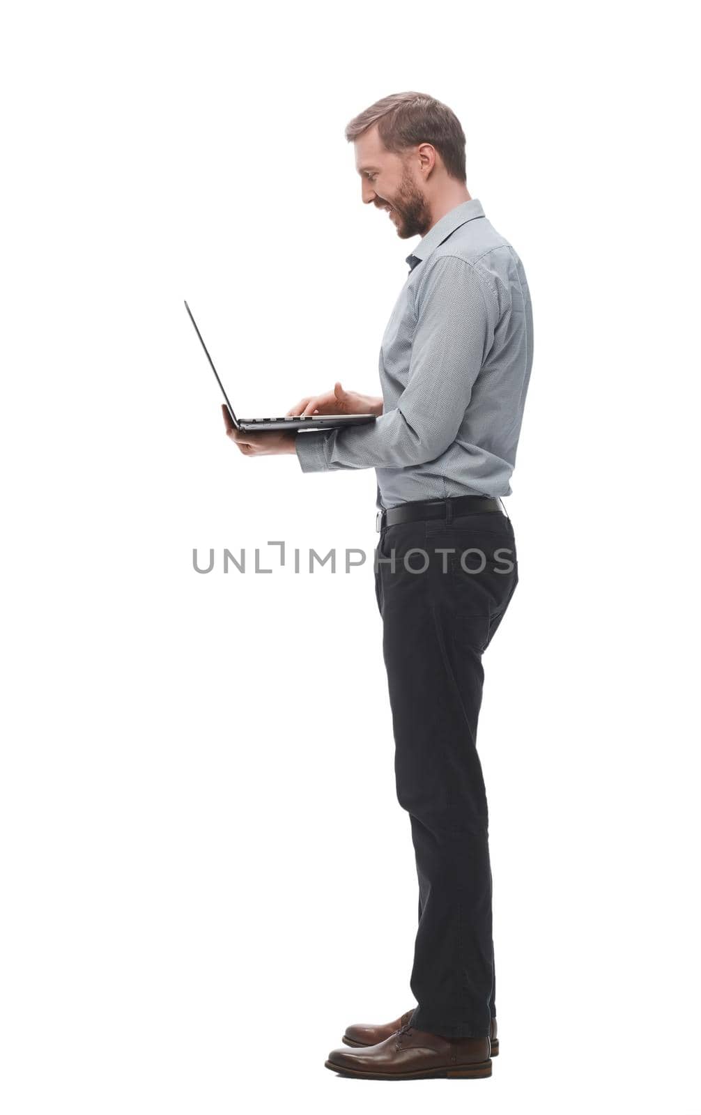 in full growth. smiling young businessman with laptop. isolated on white background