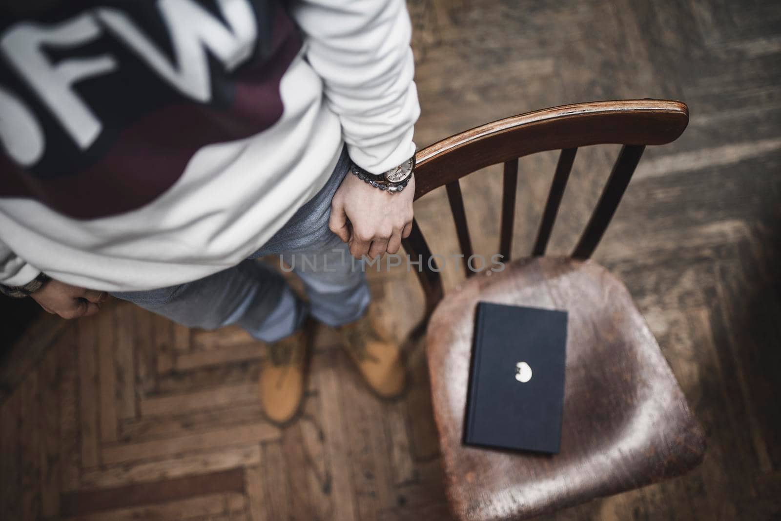 The guy at the library holds a hand on a chair by AndriiDrachuk