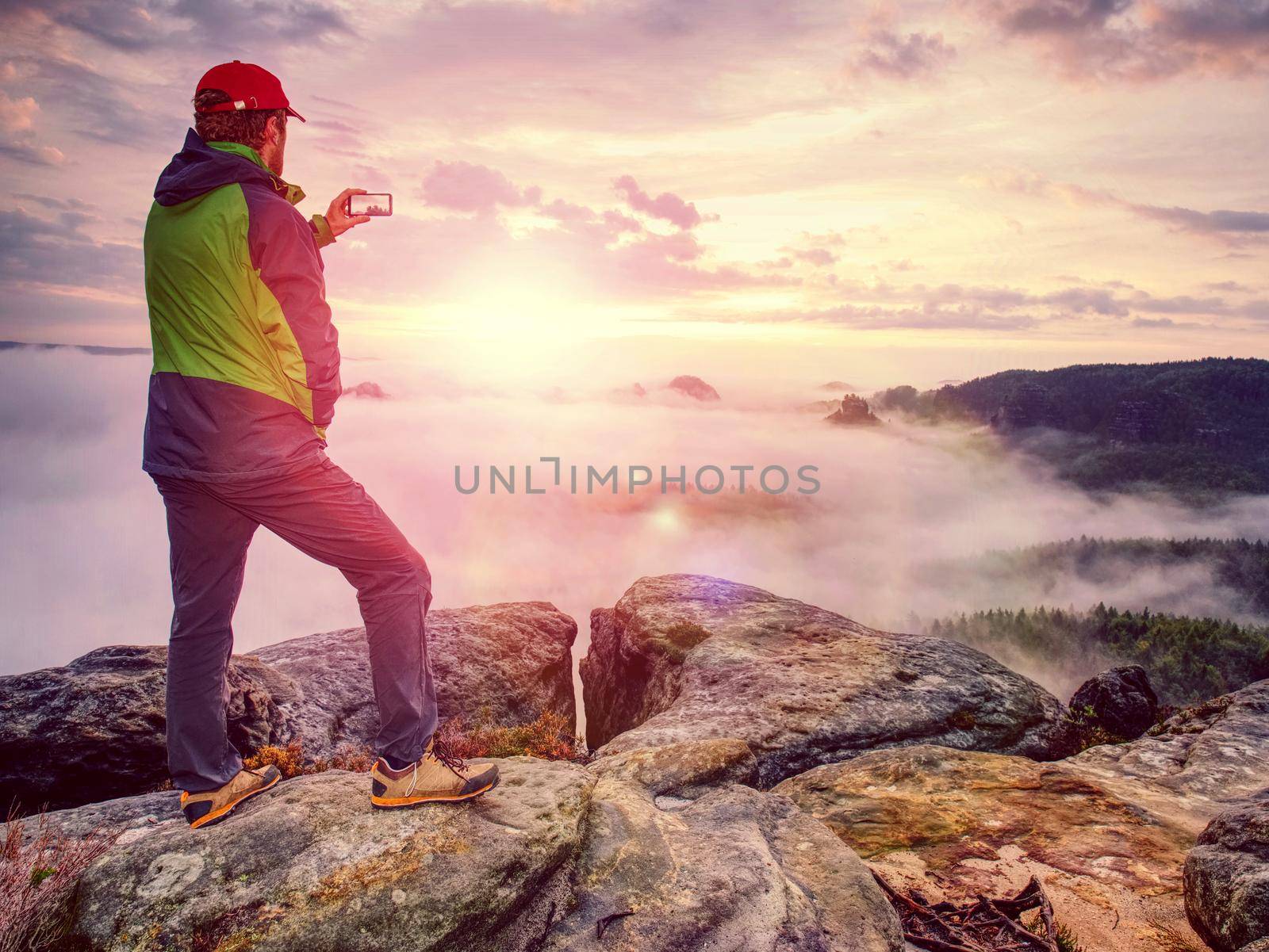 Blogger taking photo by smartphone of fall sunset mountains  by rdonar2