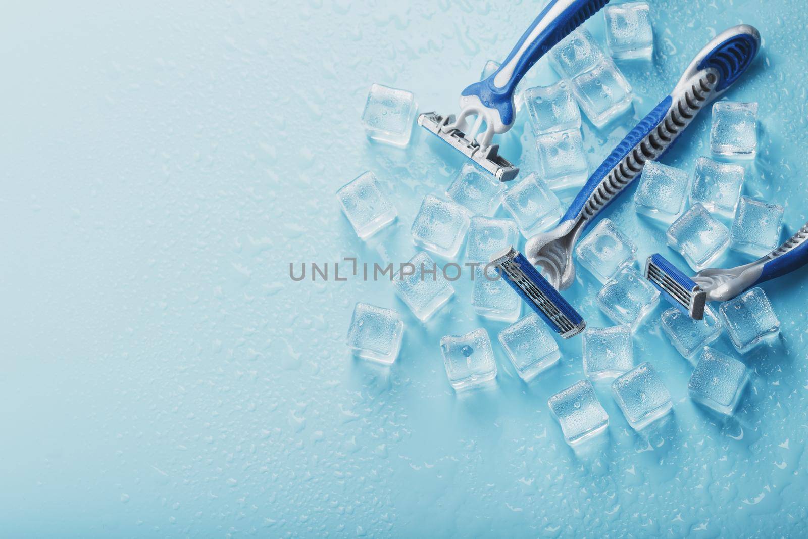 Three shaving machines on a frosty blue background with ice. The concept of cleanliness and frosty freshness by AlexGrec