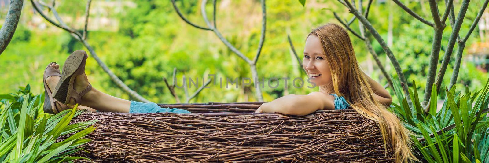 BANNER, LONG FORMAT Bali trend, straw nests everywhere. Young tourist enjoying her travel around Bali island, Indonesia. Making a stop on a beautiful hill. Photo in a straw nest, natural environment. Lifestyle.