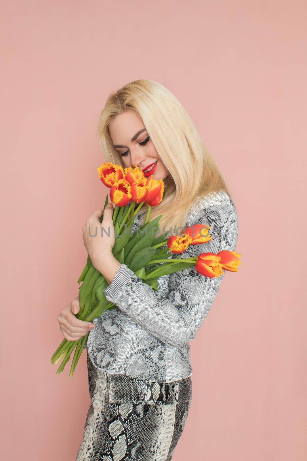 Blonde woman in snake suit holding bouquet tulips by Bonda