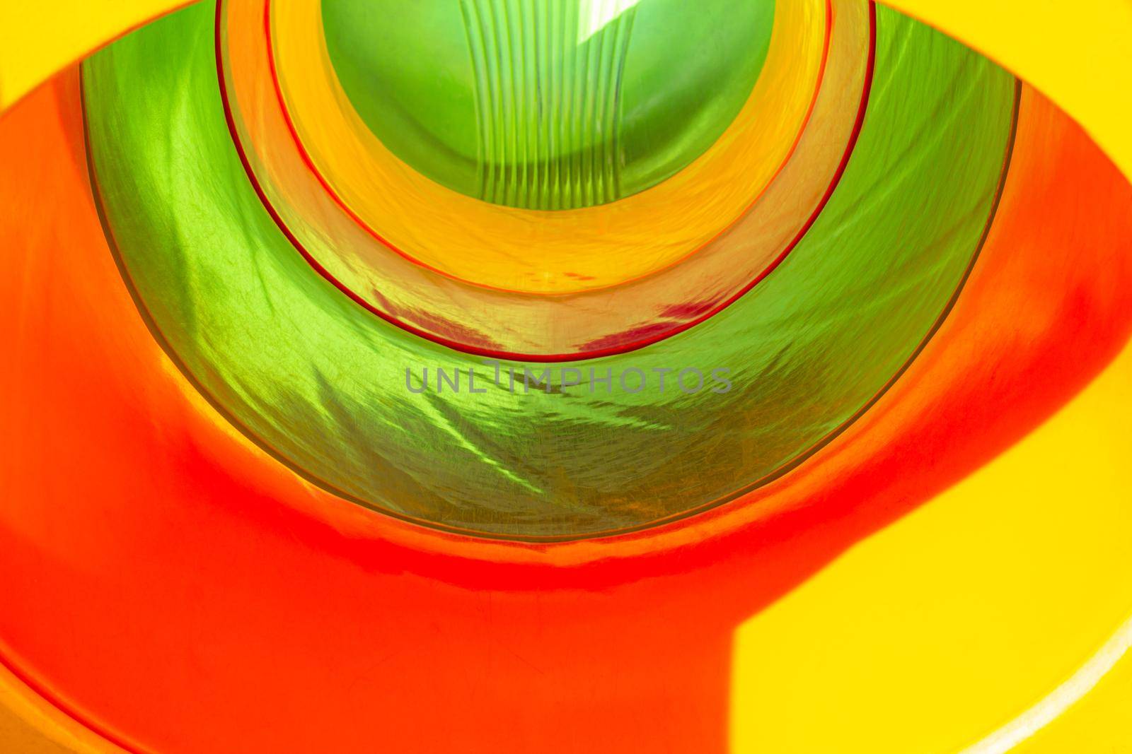 Background. The tunnel is visible from the inside in different colors. Children's slide inside. For the design.