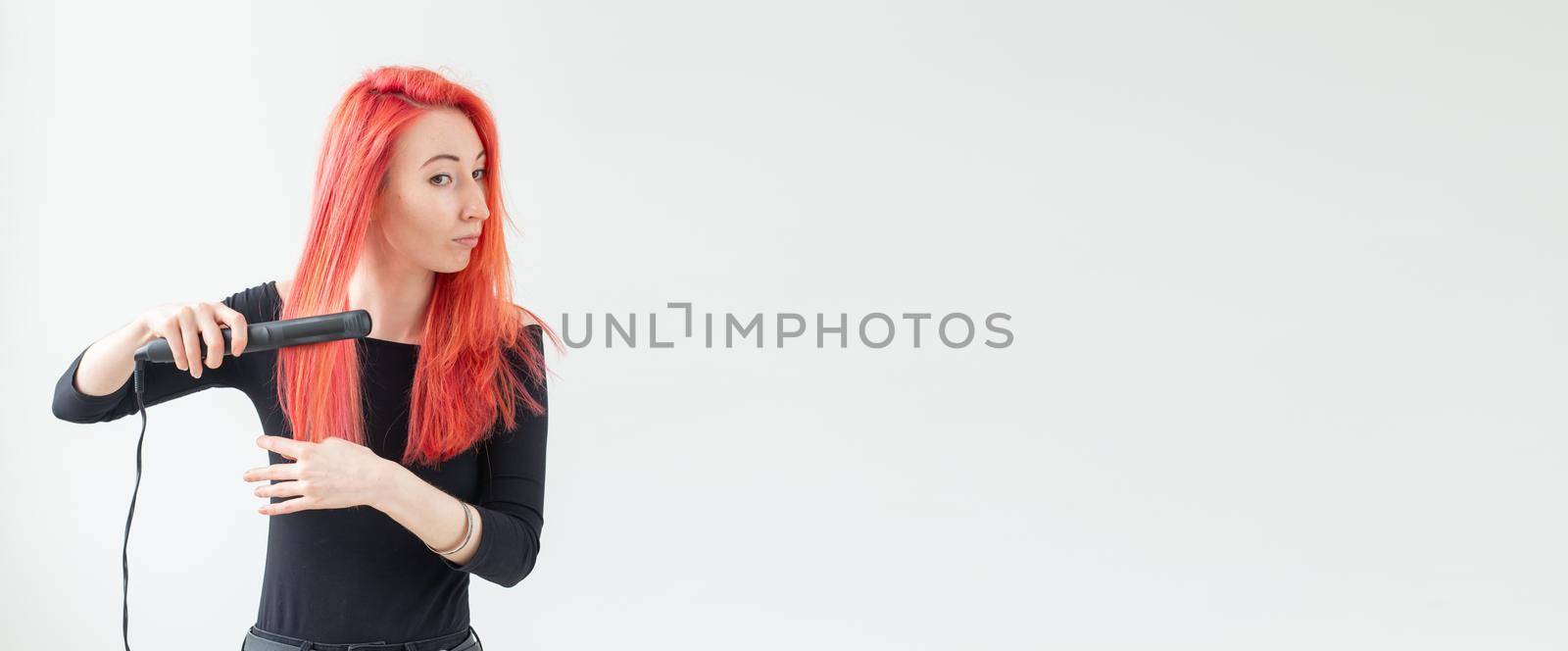 Hair style, hairdresser and people concept - stylish red-haired woman with curling iron on white background