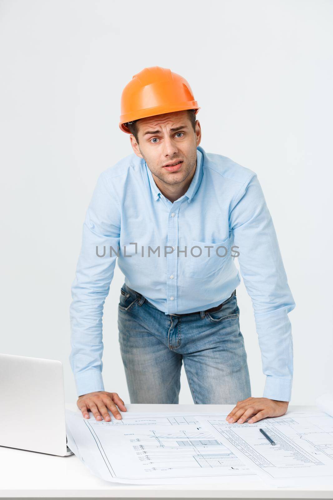 Stressed young constructor having headache or migraine looking exhausted and worried isolated on white background with copy space.