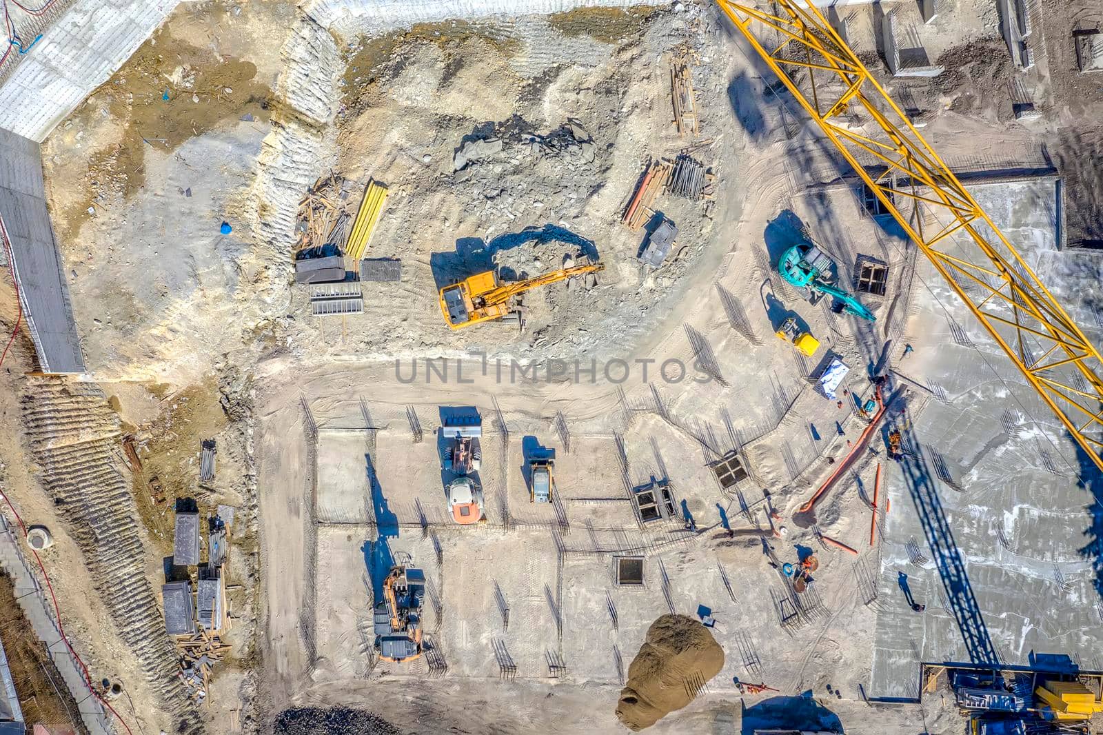 Construction equipment working at the construction site. Aerial view from drone