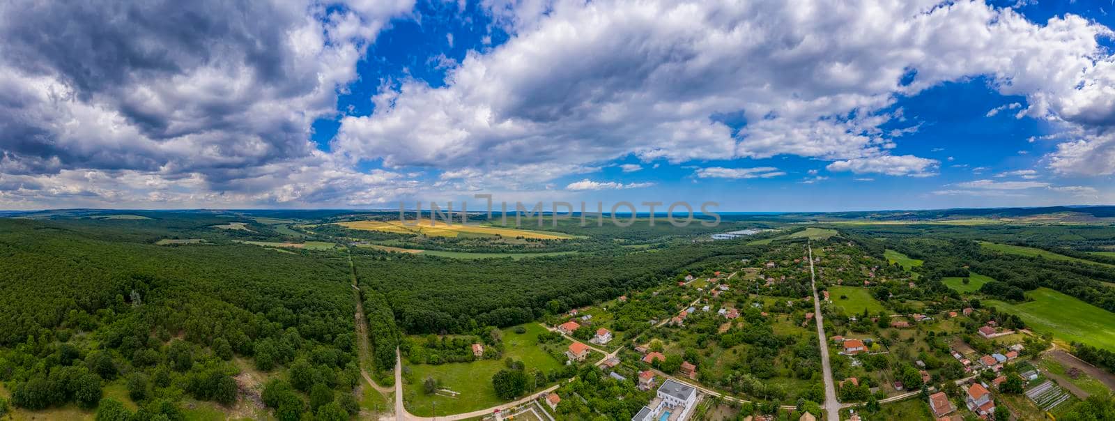 Stunning aerial panorama from a drone of countryside, village, green fields and trees, agriculture concept. 