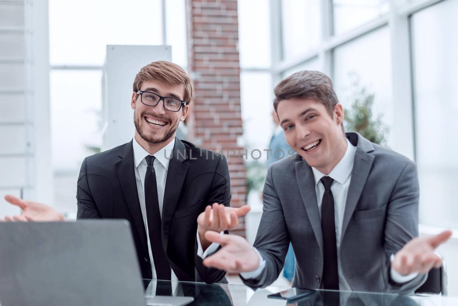 close up. two friendly businessmen sitting at the office Desk. business concept