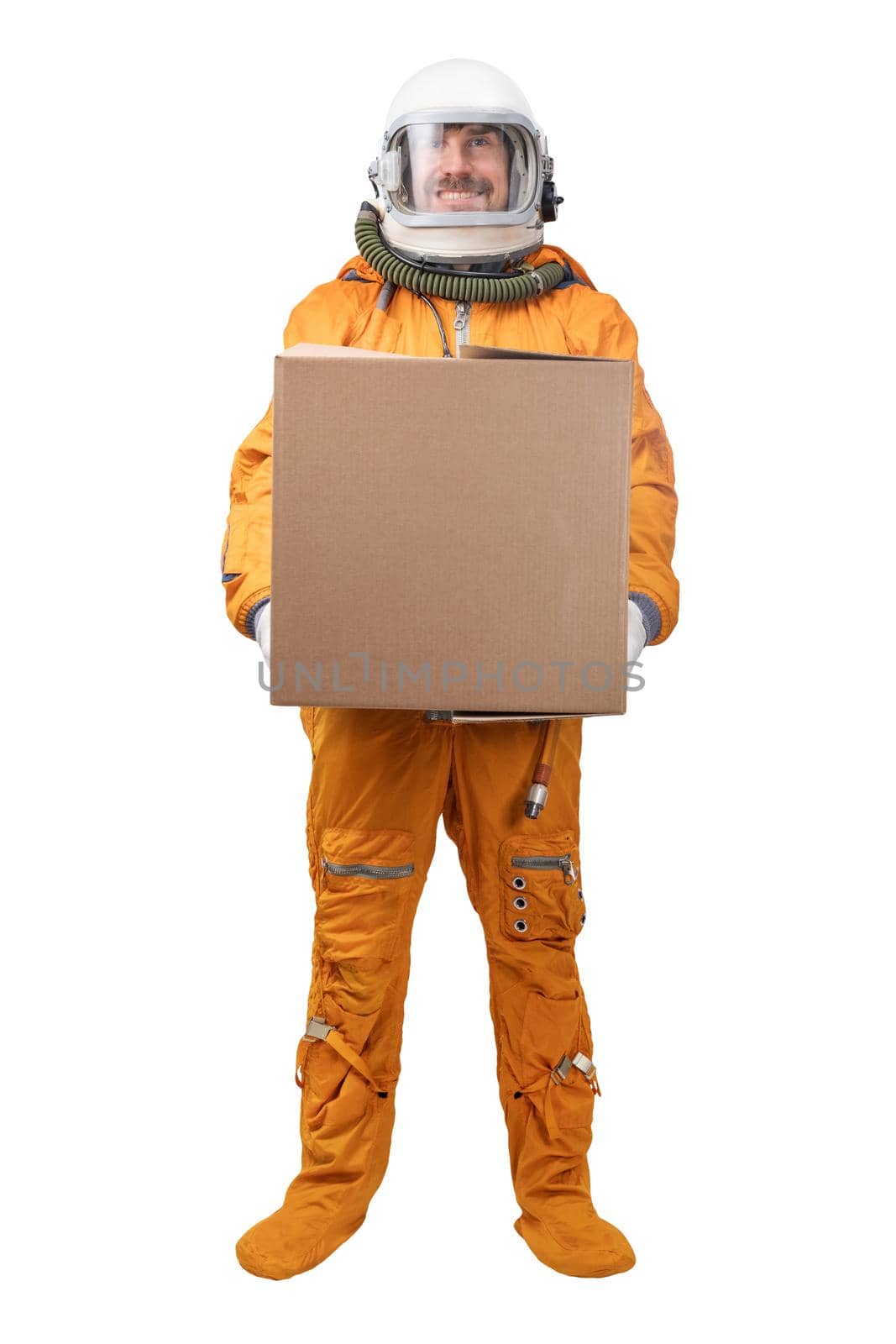 Astronaut wearing orange space suit and space helmet holding in hand blank square cardboard box isolated on white background by dmitryz