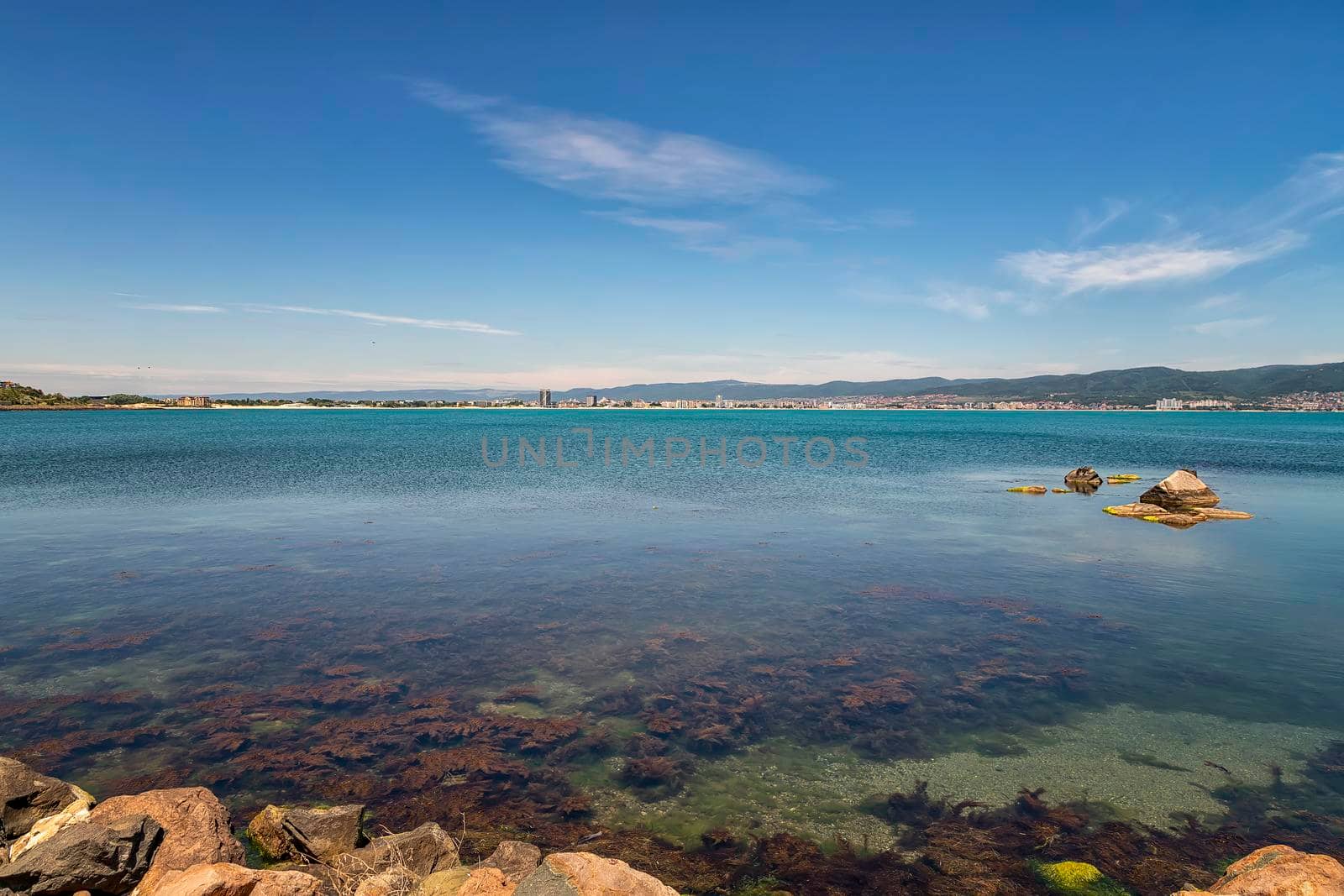 clear weather summer daytime scenic view of sea bay and rocky shore line  by EdVal