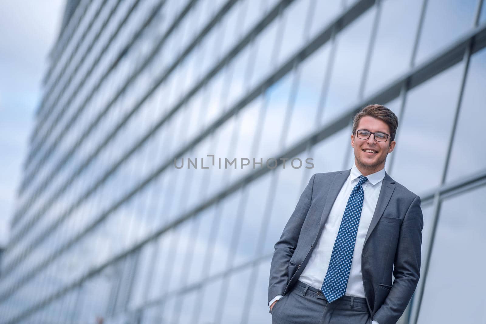 smiling business man standing near office building. photo with copy space