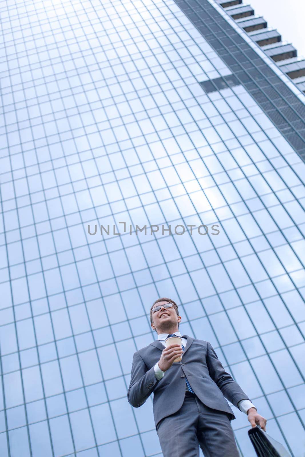 modern business man standing near a tall office building by asdf