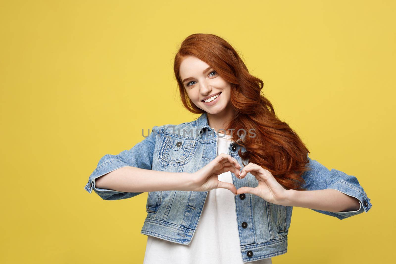 Lifestyle Concept: Beautiful attractive woman in denim making a heart symbol with her hands by Benzoix