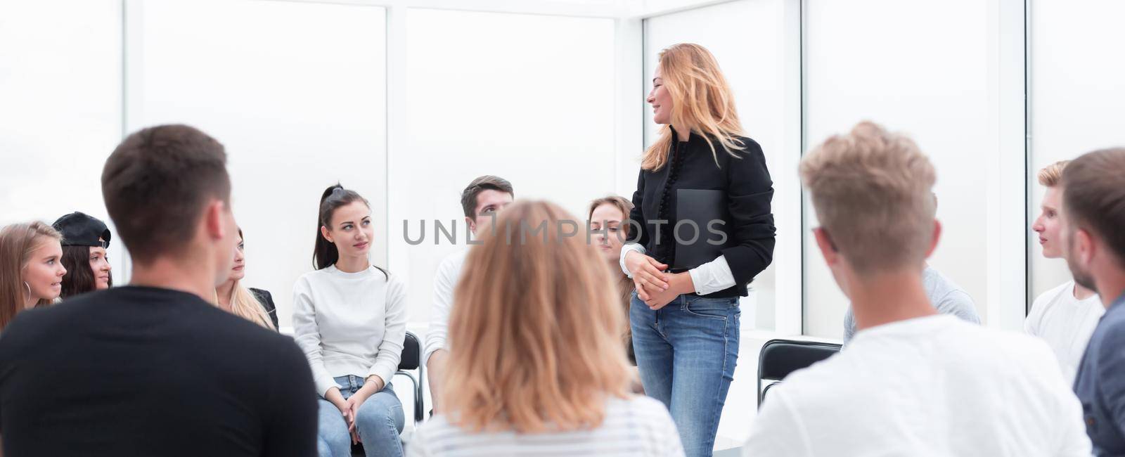 young woman standing in a circle of her colleagues. by asdf