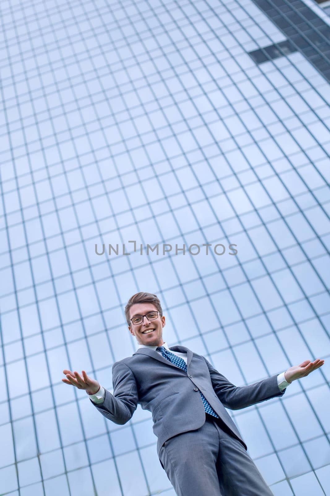 friendly businessman standing in front of a large office by asdf