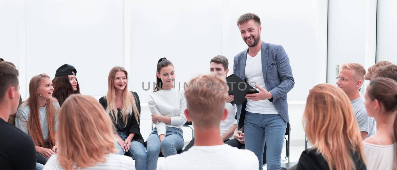 business coach standing in a circle of young people. the concept of team building