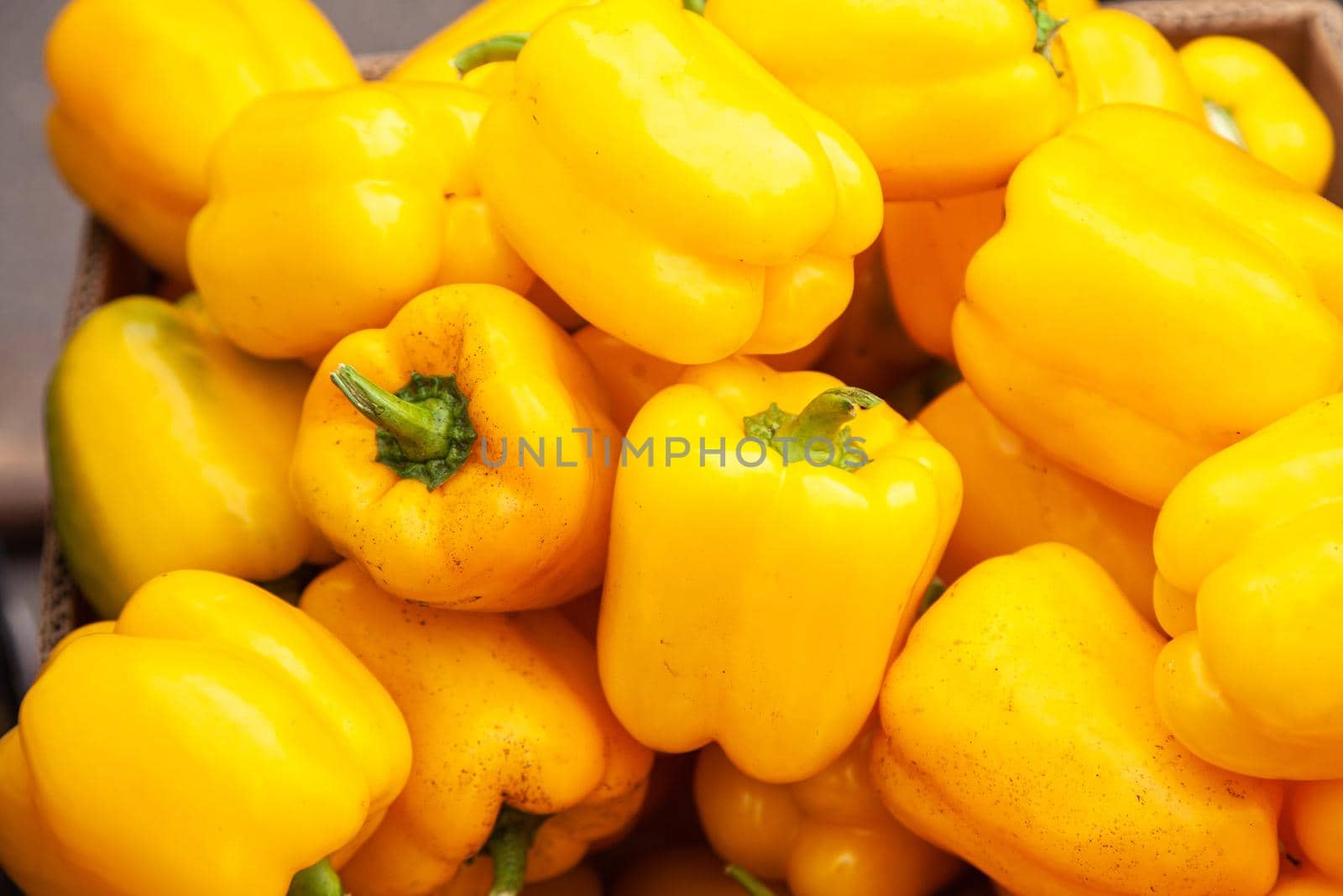 Fresh yellow pepper lying on the market counter. Yellow pepper texture, bright healthy vegetables and vegetatarian texture of yellow peppers