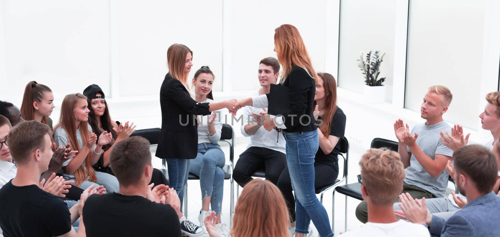 young people shaking hands in a circle of like-minded people by asdf