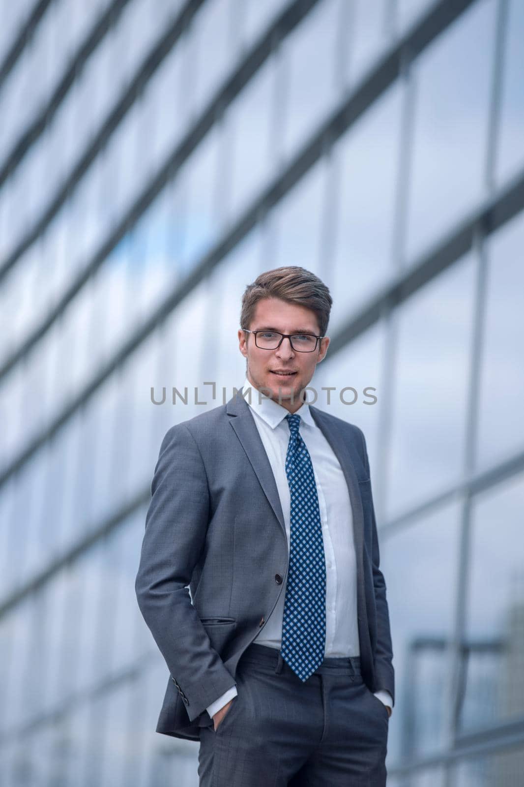 smiling business man standing near office building. photo with copy space