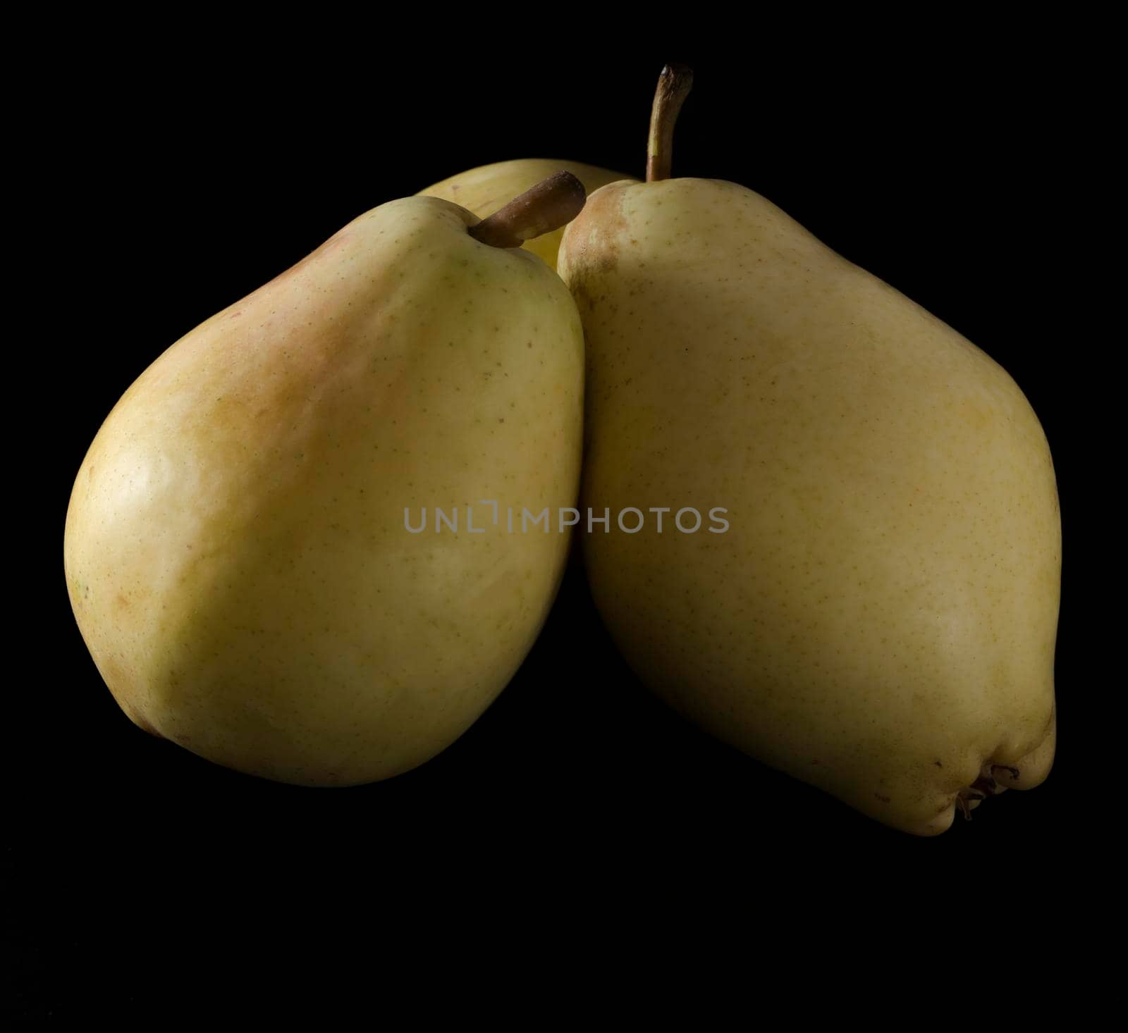 three ripe, juicy pears, on a black background