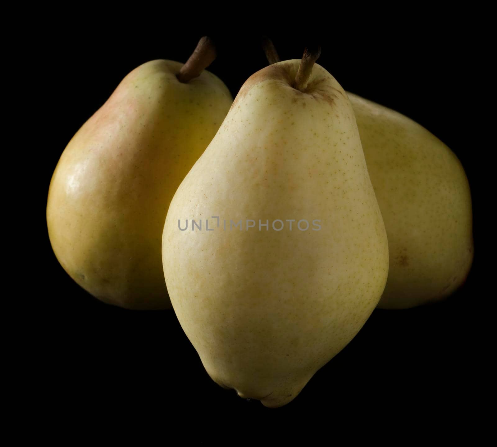 three ripe, juicy pears, on a black background