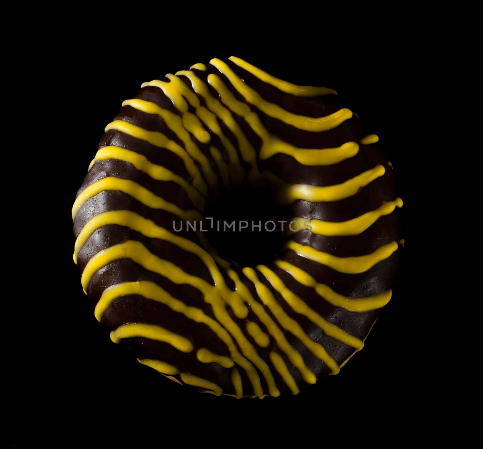 American donut covered with chocolate, on black background