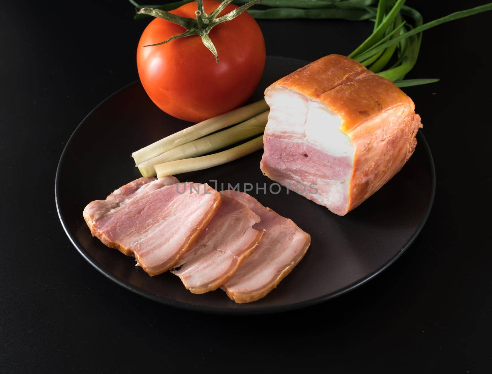 Food, Sliced bacon, tomato green onion, on a black plate, on a black background