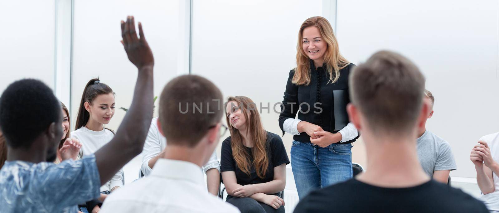 young woman standing in a circle of her colleagues. by asdf