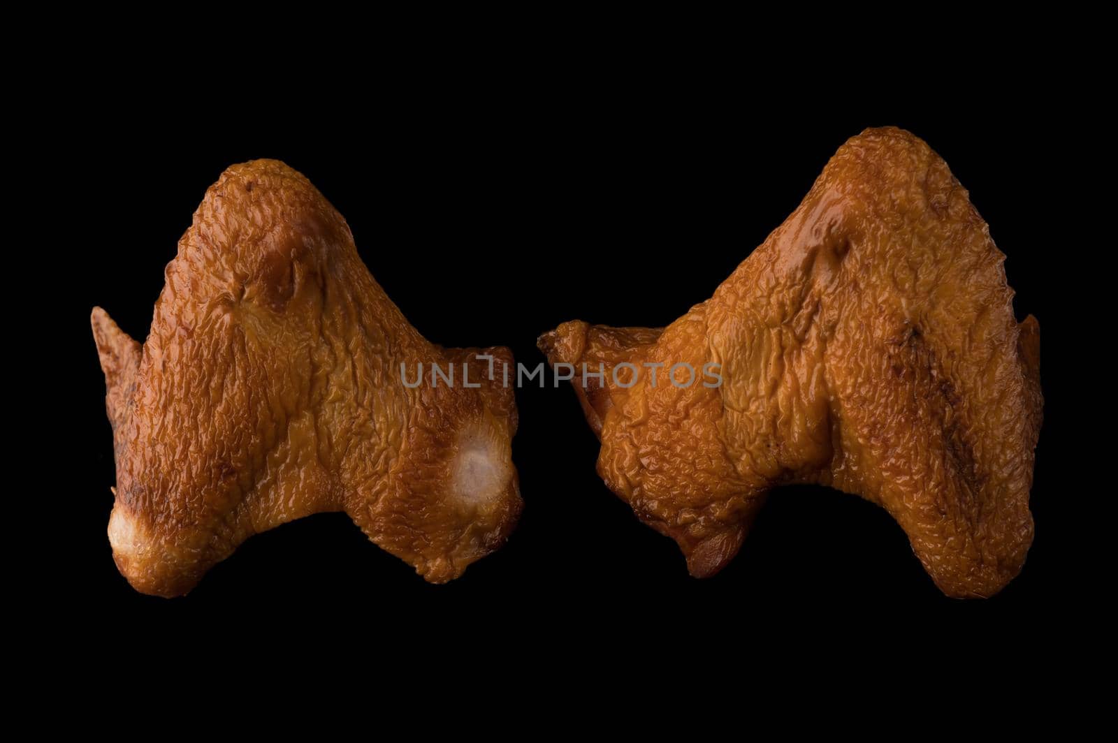 Smoked appetizing chicken legs, chicken lids, on a black background in isolation poultry meat, chicken smoked meat